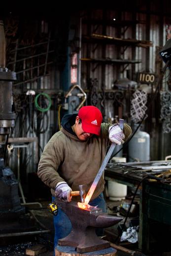 Fence World foreman Miguel Fernandez forges a fishtail scroll for a custom-made iron gate in East Sacramento. Fence World foreman Miguel Fernandez forges a fishtail scroll for a custom-made iron gate in East Sacramento.