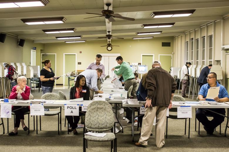 The last voter of the day, Richard Aston, checks into Poll B at Sierra 2 Center as election inspectors Geoffrey Neill and Tony Sertich (center) prepare for the final count of votes, provisional ballots and mail-in ballots delivered to the poll.