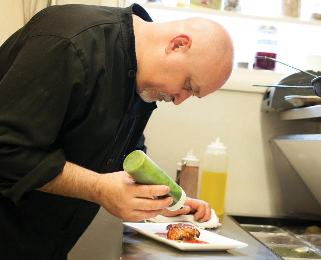 Chef Bret Bohlmann adds pesto drizzle to Boulevard Bistro’s foie gras — a staple at any French bistro.