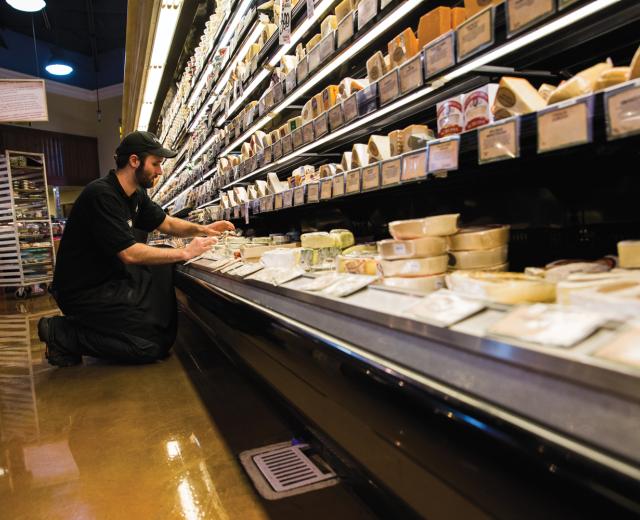 Nugget Market Cheese Manager Kyle Smelosky rearranges product before the afternoon rush