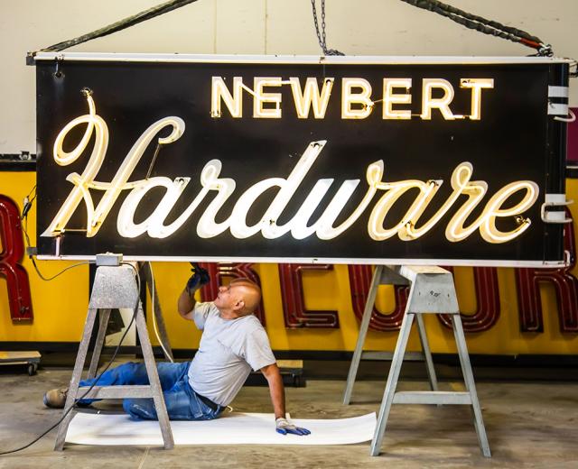 Signs for Newbert Hardware and Tower Records await a tune-up from Pacific Neon electrician Sergio Romero. (Photos by Joan Cusick)

