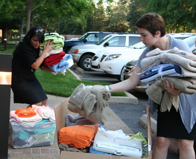 Women in Philanthropy members sort through towels donated for local emancipating foster youth.

