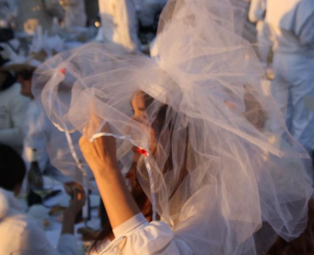 Le Dîner en Blanc organized in the Cour Napoléon of the Louvre in 2013. (Photography by ParisSharing via Wikimedia)