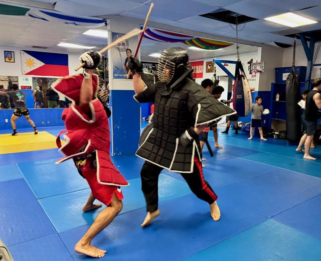 Sacramento eskrimadors Jeremy Mayberry-Antolin, left, and Charley Malagum spar inside the Rancho Cordova Martial Arts Center. (Photo by Scott Thomas Anderson)