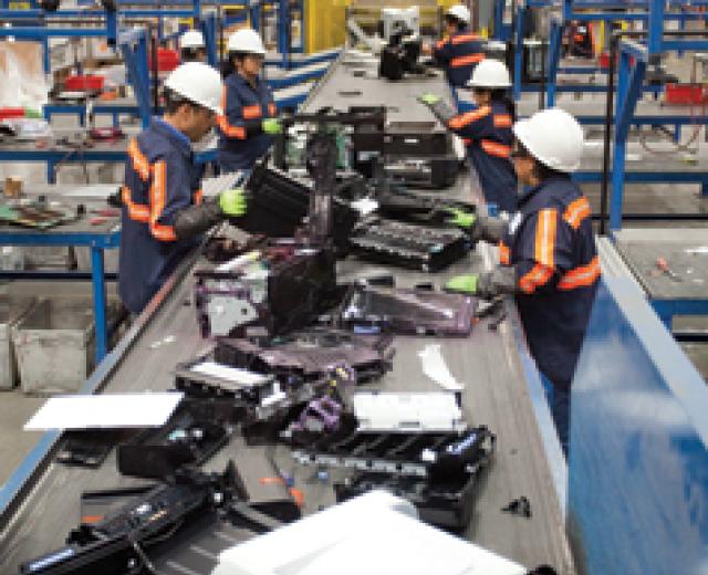 Workers process e-waste at Sims Recycling Solutions in Roseville