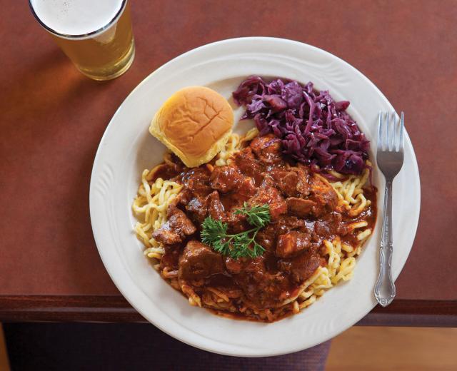 Hungarian pork sirloin goulash stewed with onion, garlic, paprika, caraway and red cabbage, served with spatzle and a pint of Warsteiner Pilsner