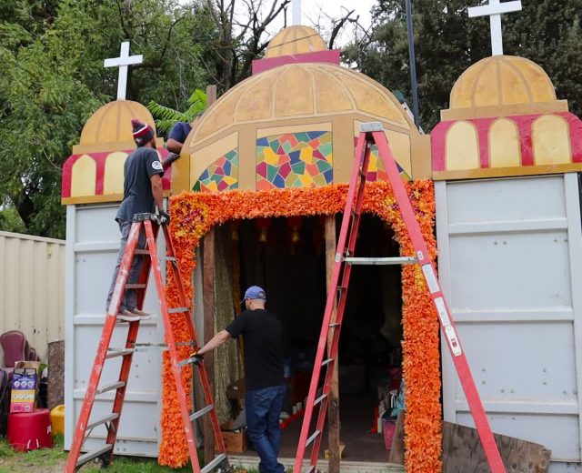 Volunteers hang marigolds at the Latino Center of Arts & Culture's El Panteón. (Photos by Melissa LuVisi)