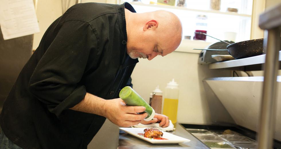 Chef Bret Bohlmann adds pesto drizzle to Boulevard Bistro’s foie gras — a staple at any French bistro.