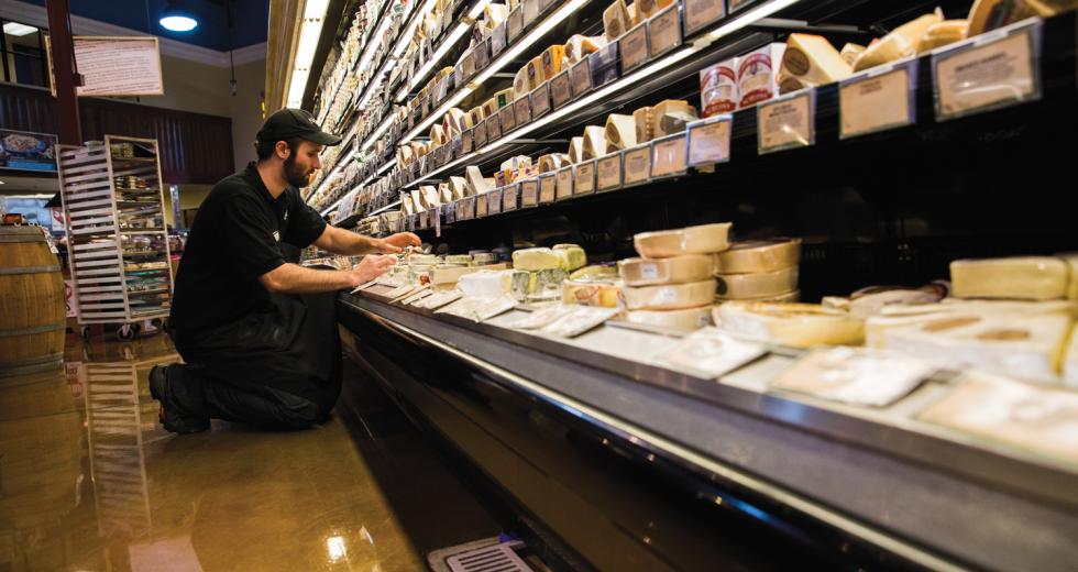 Nugget Market Cheese Manager Kyle Smelosky rearranges product before the afternoon rush