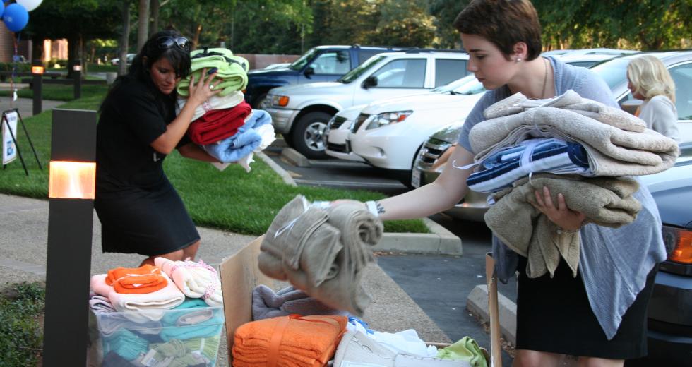 Women in Philanthropy members sort through towels donated for local emancipating foster youth.

