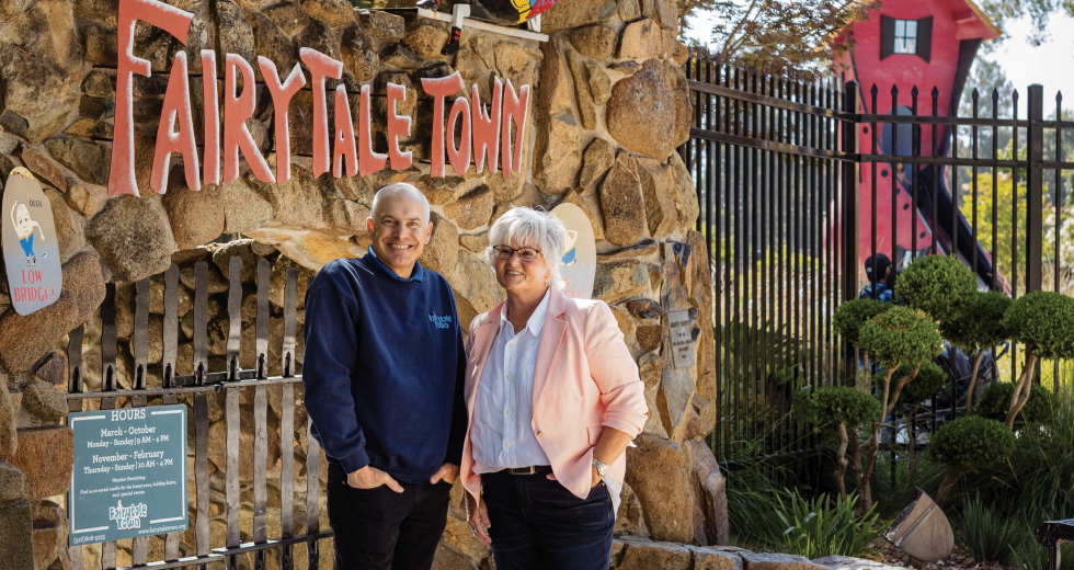 Director Kevin Smith-Fagan and Francie Dillon, a Sac State arts educator who wrote stories and songs for the whimsical storybook playsets, stand outside the entrance to Fairytale Town. (Photo by Wes Davis)