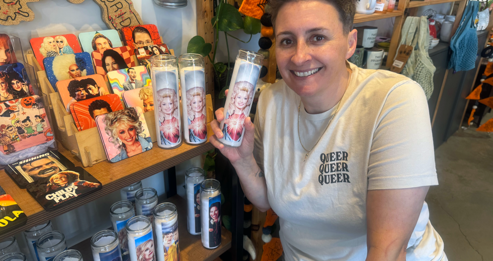 Susan Stewart kneels by a Dolly Parton candle at Strapping in Oak Park on Tuesday, September 8. (Photo by Helen Harlan)