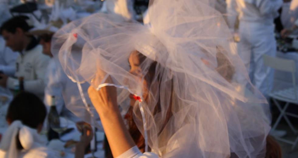 Le Dîner en Blanc organized in the Cour Napoléon of the Louvre in 2013. (Photography by ParisSharing via Wikimedia)