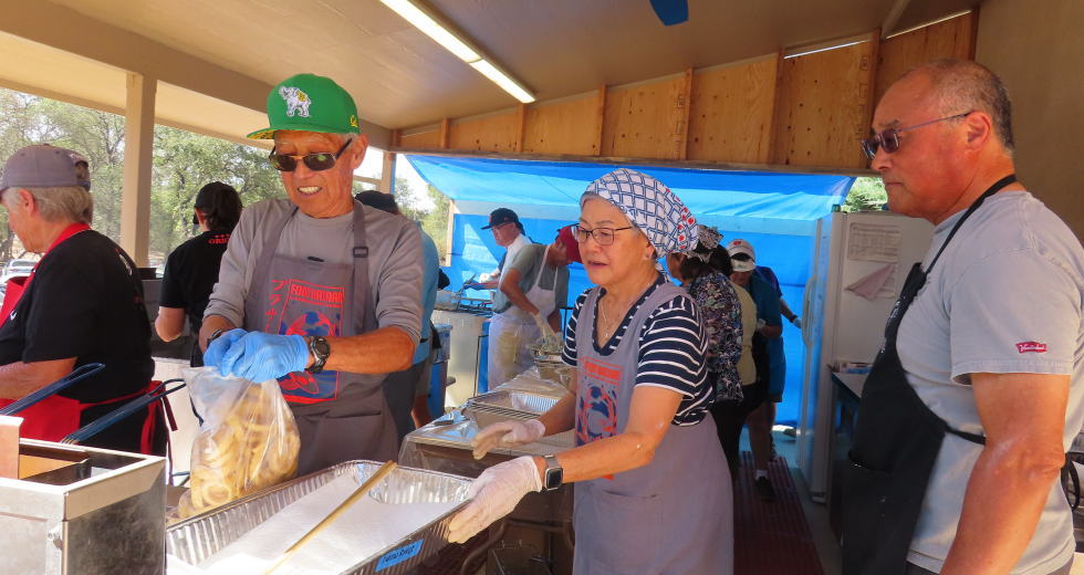 Volunteers prepare grilled meat for festivalgoers, one of several foods prepared on-site during the annual event. (Photo by Adiva Mittal)