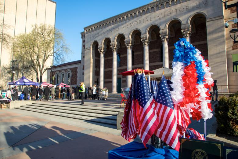 Monthly naturalization ceremonies at Memorial Auditorium draw early-morning vendors, including volunteers who help the new citizens register to vote. The line begins forming before 8 a.m., and it takes nearly two hours for candidates to check in and be seated.