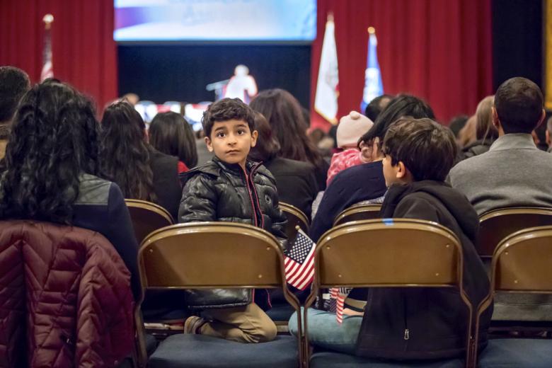Inside the auditorium, Khaleel and the boys are seated in a separate section from Zuhal.