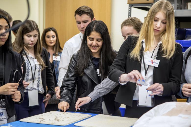 Sarina Dhillon (center) takes a cotton swab to test for blood stains. The Oakmont High School junior is interested in a medical or forensic career.