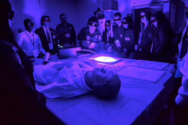 Students view stains under an ultraviolet light during their hands-on session with the FBI Evidence Response Team.