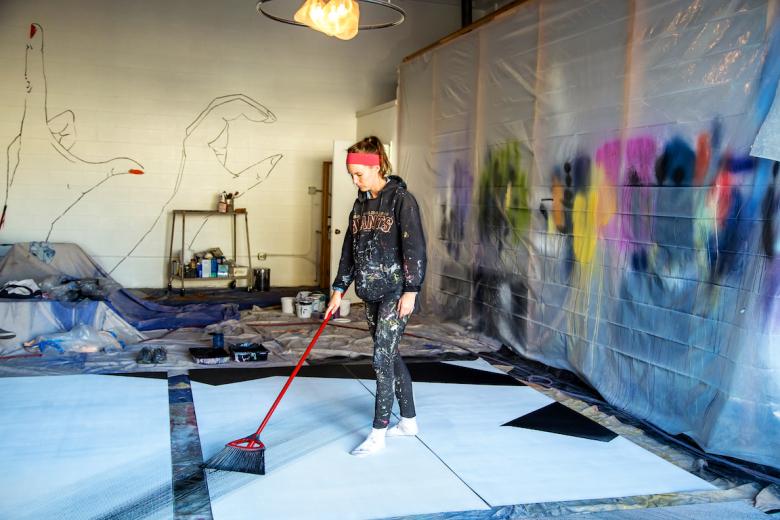 Hennessy Christophel of LC Mural Design uses a broom to paint mural panels Hennessy Christophel of LC Mural Design uses a broom to paint mural panels