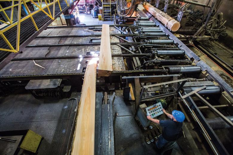 Running the logs through a computerized laser scanner, manufacturers can measure to a thousandth of an inch. Butch Tittle, an off-bearer, looks at the logs and determines where to send the sawed pieces based on size and grade. Running the logs through a computerized laser scanner, manufacturers can measure to a thousandth of an inch. Butch Tittle, an off-bearer, looks at the logs and determines where to send the sawed pieces based on size and grade.