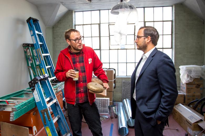 Artist Sean Burner (left) discusses his lobby installation, which will feature a 1914 Lawrence Warehouse fire bell, with developer Ali Youssefi Artist Sean Burner (left) discusses his lobby installation, which will feature a 1914 Lawrence Warehouse fire bell, with developer Ali Youssefi