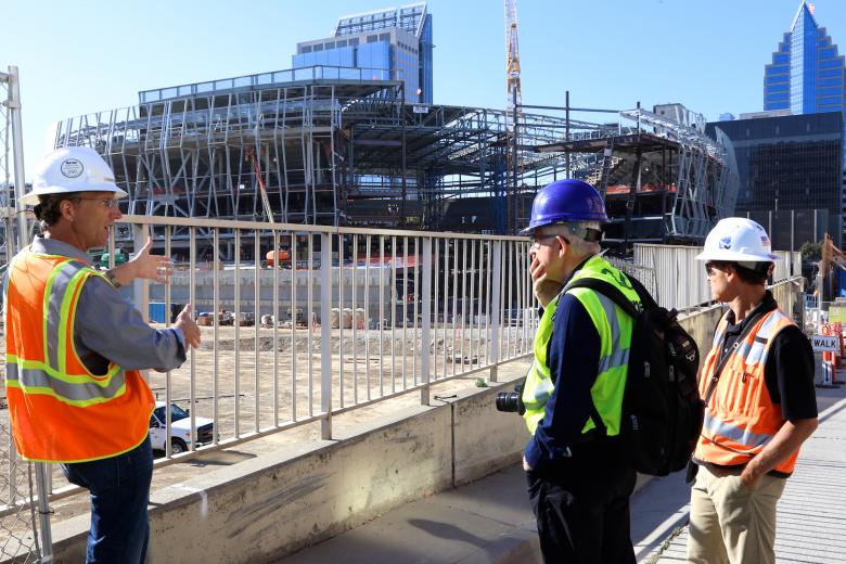 Tour guides Mark Posnick (left) and Jamie Brown of Turner Construction (right) describe arena construction to artist Bill Fontana. Tour guides Mark Posnick (left) and Jamie Brown of Turner Construction (right) describe arena construction to artist Bill Fontana.