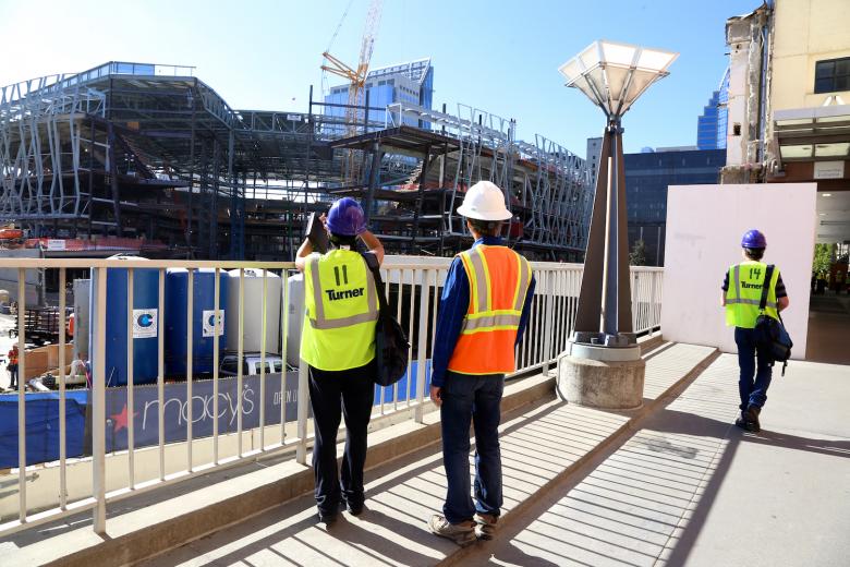 Artists JD Beltran and Scott Minneman stop on the walkway outside the old Downtown Plaza to take photos of the new arena construction site.
Artists JD Beltran and Scott Minneman stop on the walkway outside the old Downtown Plaza to take photos of the new arena construction site.
