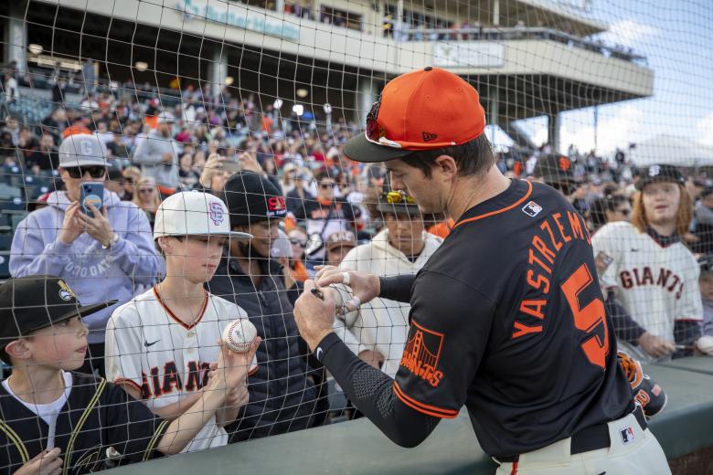 Giants outfielder Mike Yastrzemski signs autographs for fans along the left field line at Sutter Health Park on March 24.