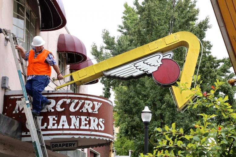 Pacific Neon workers first removed the flashing yellow arrow, with the wings of Mercury. Pacific Neon workers first removed the flashing yellow arrow, with the wings of Mercury.