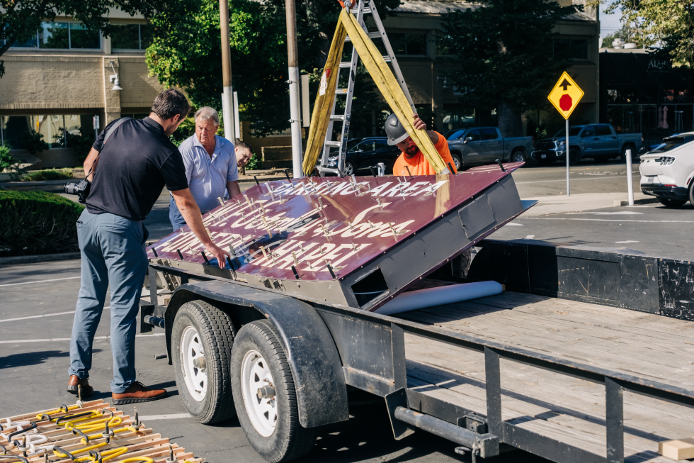 The sign is lowered onto a flatbed truck in preparation for its move to the funeral home's new location. (Photo by Francisco Chavira)