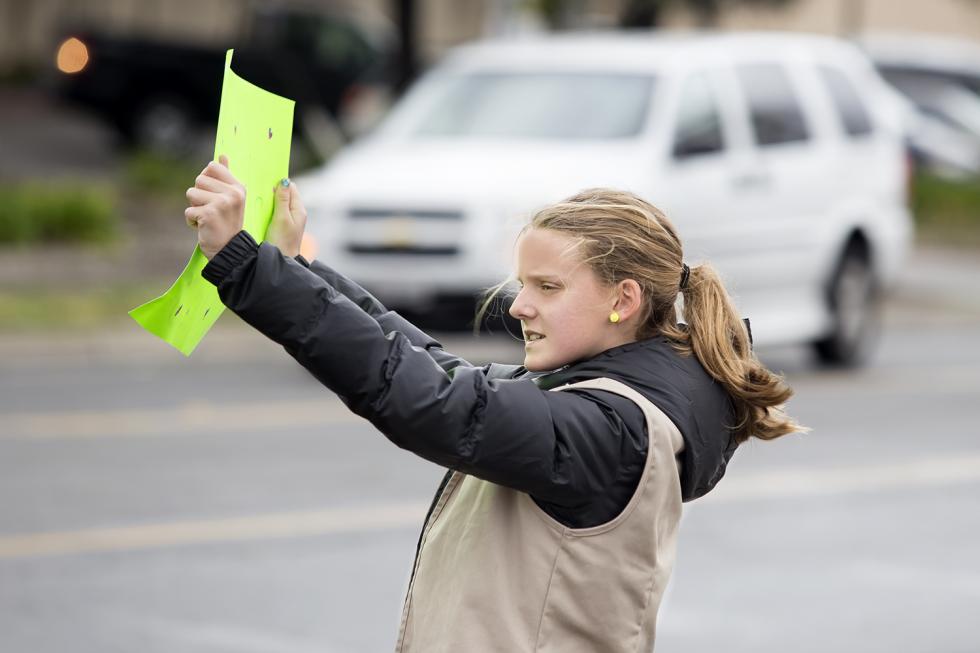 Sophie Esley holds up a sign encouraging drivers to stop for cookies.
