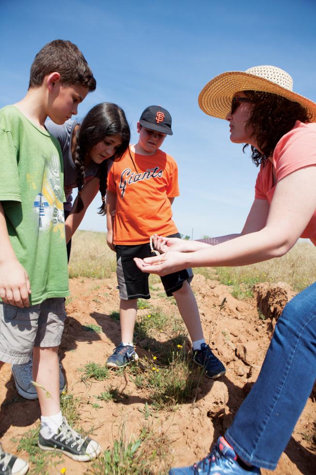  Emily Butler, executive director of Sac Splash, discusses with students the discovery of a snakeskin found inside the vernal pools they were exploring.