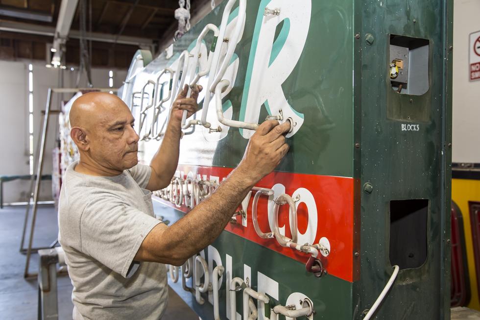 Pacific Neon electrician Sergio Romero removes the neon tubes on the Sleeper Stamps & Stationery sign.
(Photos by Joan Cusick)