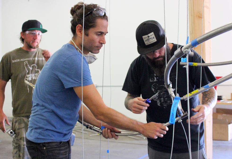 Bryan Valenzuela (left) and Jay Campbell work on the spines of the sculpture in a Sacramento warehouse in mid-August, as Matt Dowd watches.
