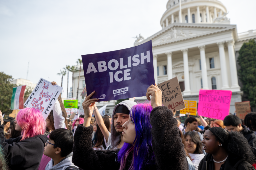 A protester holds a sign printed by Sacramento Councilmember Mai Vang's congressional campaign.