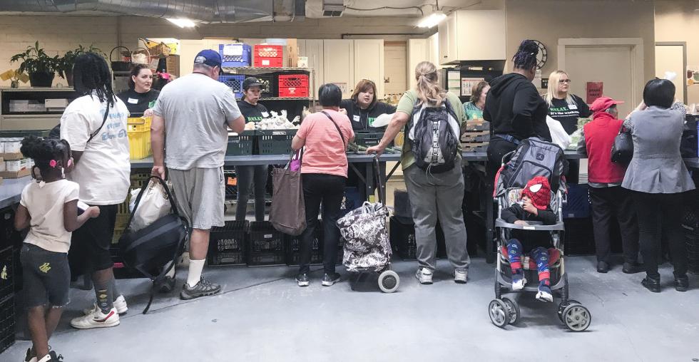 People pick up produce, canned goods, meat, dairy and bread at the River City Food Bank in Sacramento. (Photo by Jackie Botts for CalMatters)