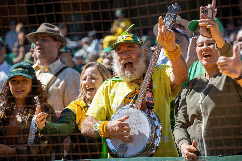The A’s’ “Banjo Man,” Stacy Samuels, has been playing at A’s games for around 30 years, wandering the stands in a green and gold cape and a propeller beanie hat playing his banjo.