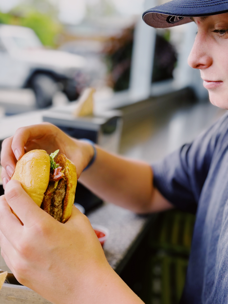 The author's son, with whom she regularly travels along the I-80 corridor for hockey games, enjoys a burger at Burger & Cream. (Photo by Nicolle Sloane)
