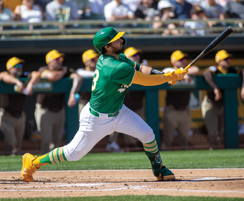 A’s catcher Shea Langeliers lifts a fly ball to center field in the bottom of the first inning of a spring training game against the San Diego Padres on Feb. 27 at Hohokam Stadium in Mesa, Arizona.