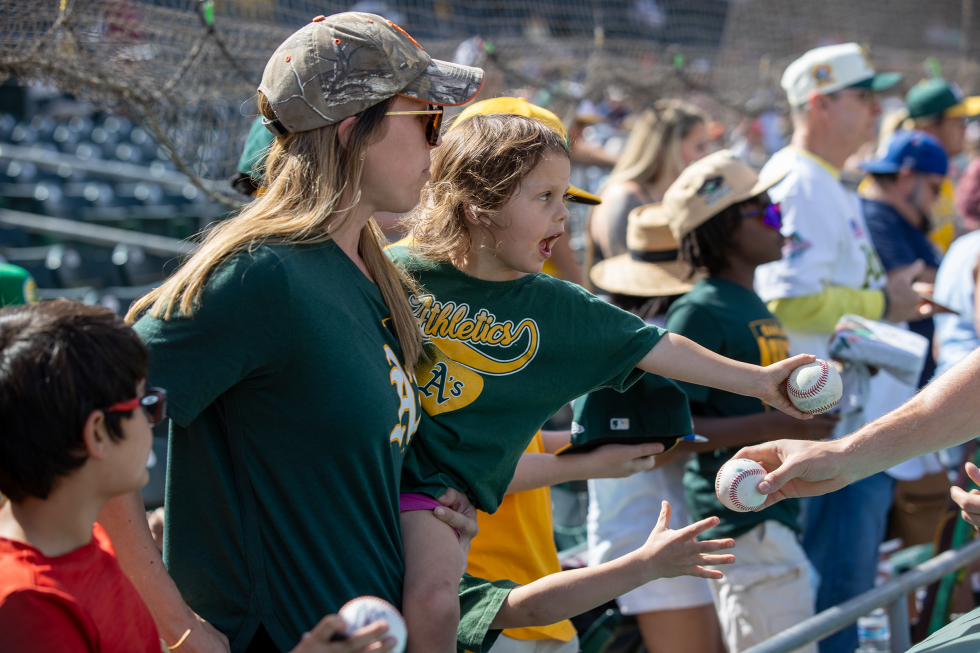 Jenifer Spinardi and daughter Eleonora, 3, of Turlock attempt to get a player’s autograph before the spring training game on February 28 at Hohokam Stadium in Mesa, AZ.