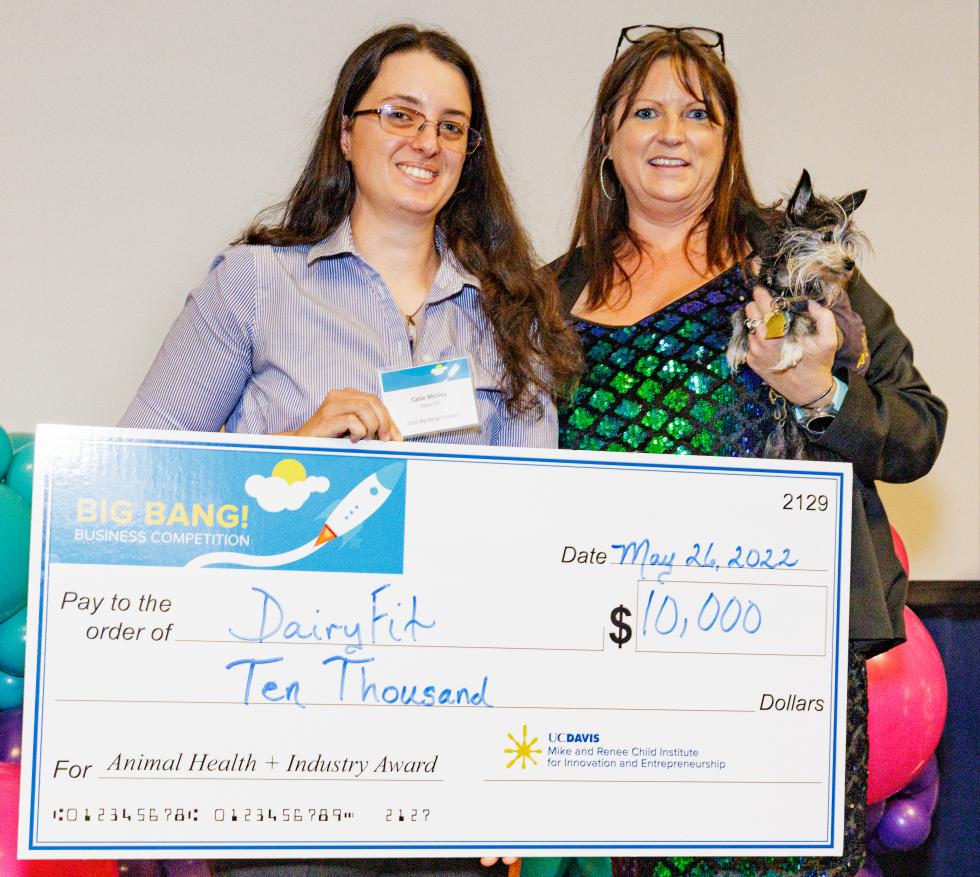 UC Davis Ph.D. candidate in animal biology Catie McVey (on the left), founder of DairyFIT, received the $10,000 Animal Health + Industry Sector Award. DairyFIT is an AI platform that provides insight into livestock health. Pictured with Niki Peterson (on the right, holding Tink), senior program manager at the UC Davis Mike and Renee Child Institute for Innovation and Entrepreneurship.