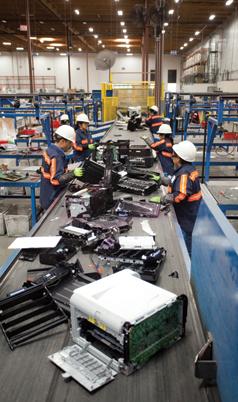 Workers process e-waste at Sims Recycling Solutions in Roseville