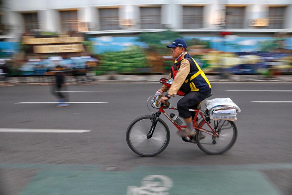A man delivers newspapers in Bandung, Indonesia. Newspapers are still delivered by bicycle in some parts of the world, but in the U.S. most delivery people use cars. (Shutterstock photo)