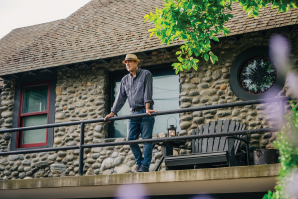 Sam Du Bose stands on the porch of his bungalow in Fair Oaks. Built in 1938, its river rock facade is a byproduct of gold miners dredging the American River. Fresh paint on the trim, round window grilles and a picture window were additions that helped transform the formerly dilapidated exterior. (Photos by Francisco Chavira)