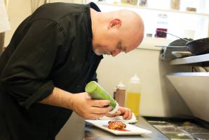 Chef Bret Bohlmann adds pesto drizzle to Boulevard Bistro’s foie gras — a staple at any French bistro.