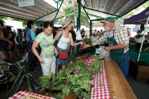 Customers browse the offerings at Davis’s farmers market on Saturday afternoon.