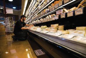 Nugget Market Cheese Manager Kyle Smelosky rearranges product before the afternoon rush