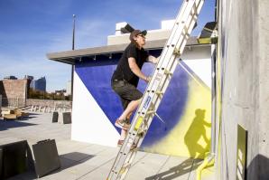 Jake Castro paints a mural on the rooftop of the Warehouse Artists Lofts in 2014. Castro is one of four Sacramento artists commissioned for the Sacramento Mural Festival. He will install his mural at the Crest Theater.