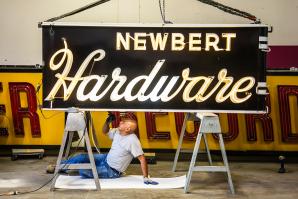 Signs for Newbert Hardware and Tower Records await a tune-up from Pacific Neon electrician Sergio Romero. (Photos by Joan Cusick)
