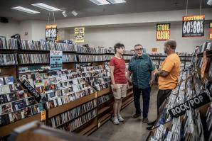 Dilyn and John Radakovitz talk with their son, Andrew, at the Dimple Records store in Roseville in September. The company closed last month after four decades. (Photo by Terence Duffy)